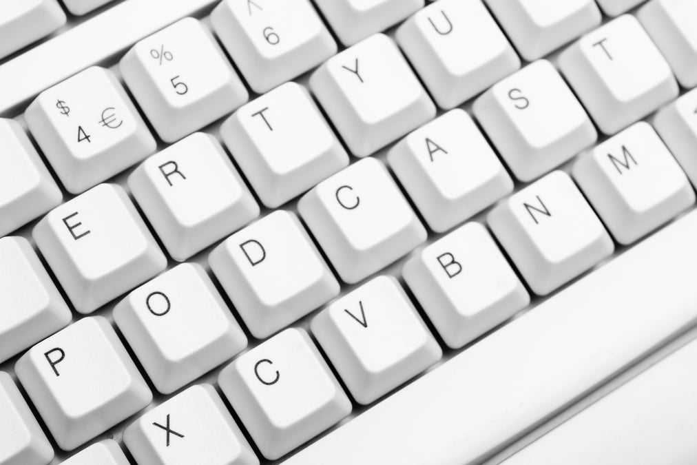 Podcast written across white computer keyboard